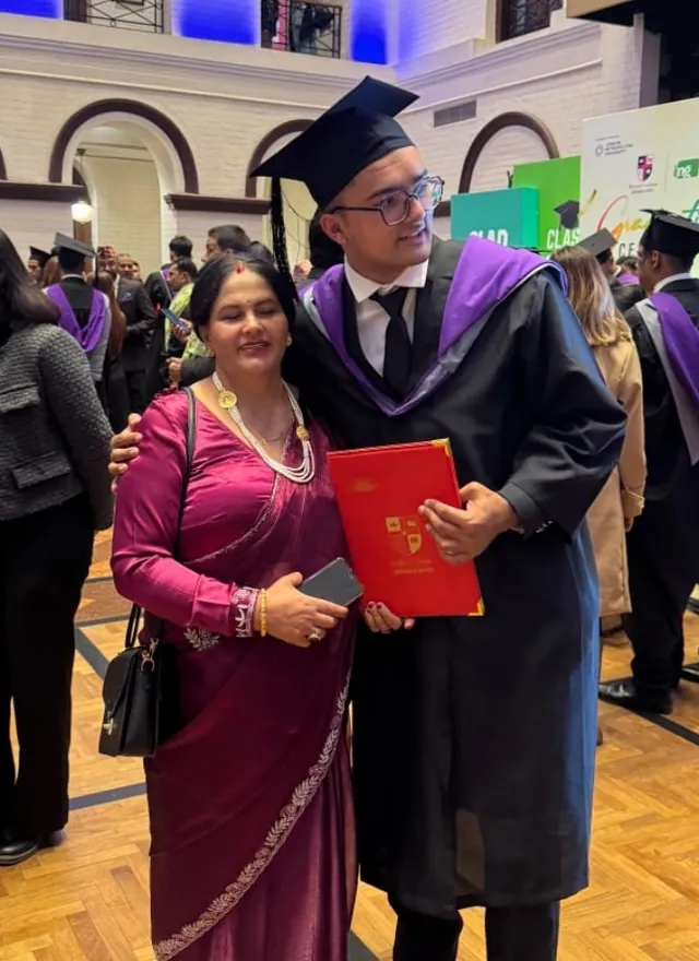 Martin at graduation with his mom, who is blinking