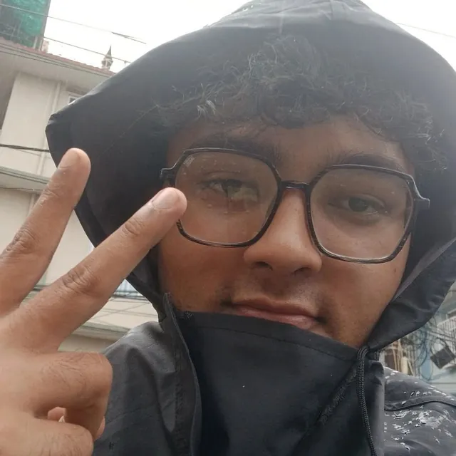 Martin in the rain, hood up, throwing a peace sign